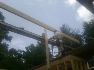 Carpenter setting a ridge beam over a new addition frame — Ice Dam Removal by Roofing Brothers in Brookpark