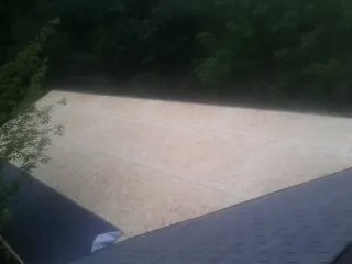 New OSB roof sheathing installed beside an existing shingle roof in Brookpark
