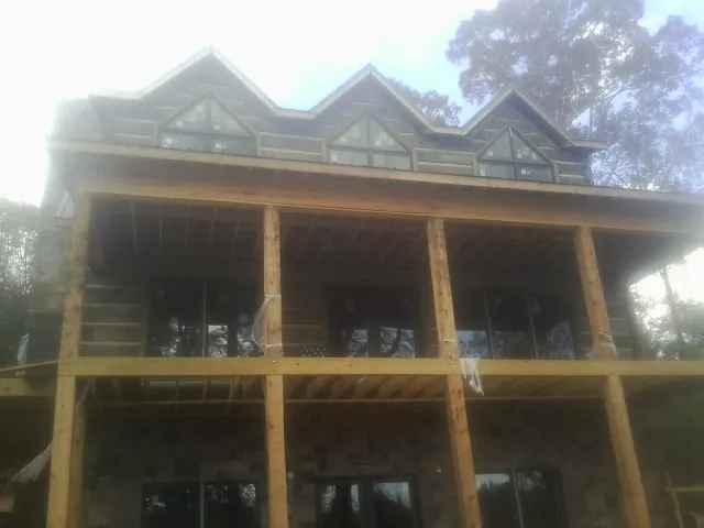 Dormers and porch framing on a large log home under construction — Roof Coating work by our crew in Brookpark