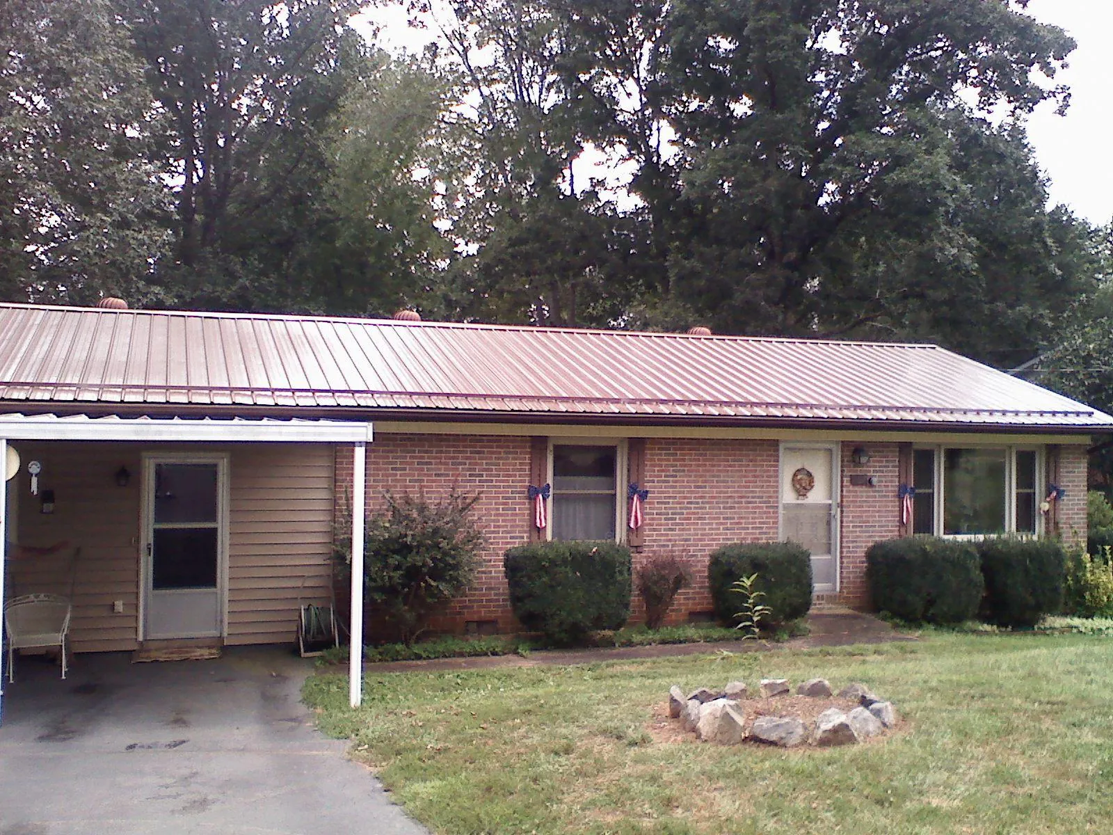 Bronze metal roof and carport on a brick ranch home — Roof Repair work by our crew in Brookpark